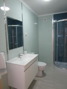 a bathroom with a white sink and a toilet at Casa Flor d'Sal in Angra do Heroísmo +40 photos