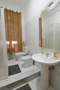 a bathroom with a white sink and a toilet at Efesto Bed & Breakfast in Catania