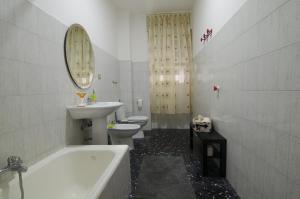 a bathroom with a sink and a tub and a toilet at Efesto Bed & Breakfast in Catania