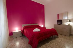 a bedroom with pink walls and a pink bedspread at Efesto Bed & Breakfast in Catania