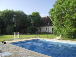 una piscina en un patio con una casa en Chambres d'hôtes Edoniaa, en Quend