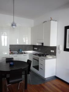 a kitchen with a black table and white cabinets at La Scala in Vernazza