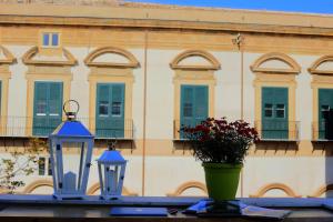 two blue lights and a vase with flowers and a building at Jardin De France in Palermo