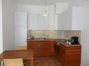 eine Küche mit Holzschränken, einer Spüle und einem Tisch in der Unterkunft Apartament Jelitkowski in Danzig