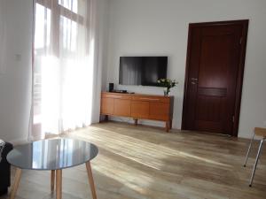 a living room with a table and a tv at Apartament Jelitkowski in Gdańsk