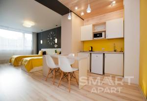 a kitchen with a table, chairs and a refrigerator at Smart Apart at Artek in Yekaterinburg