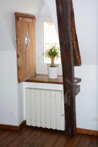 una habitación con una ventana y una planta en un estante en Loft en bulles, en Épernay