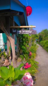 un panneau sur un bâtiment avec des fleurs sur un trottoir dans l'établissement Cast Away, à Nonthaburi