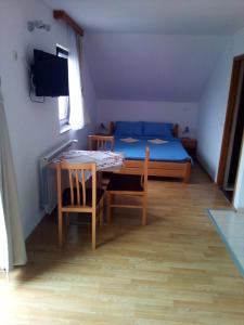 Cette chambre comprend une table, un lit, une table et des chaises. dans l'établissement Apartments Dale, à Smoljanac