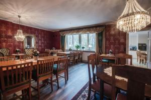 una sala da pranzo con pareti rosse e tavoli e sedie in legno di Anna´s Bed & Kitchen a Varberg
