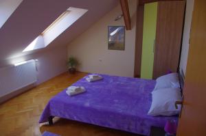 斯盧尼的住宿－托咪公寓，一间卧室配有一张紫色床和两条毛巾