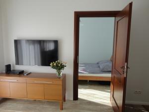 a bedroom with a bed and a dresser and a mirror at Apartament Jelitkowski in Gdańsk