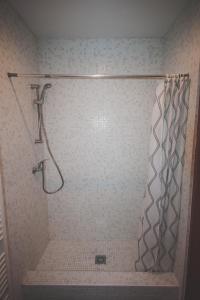 a shower with a shower curtain in a bathroom at Chata pod lesom in Drienica
