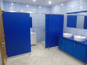 a bathroom with two sinks and a blue door at Marficas Hostel in Urzelina