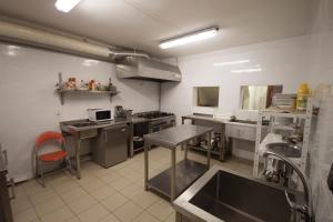 a large kitchen with a sink and a stove at Chata pod lesom in Drienica