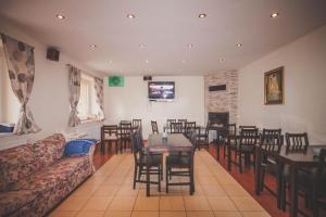 een eetkamer met tafels en stoelen en een bank bij Chata pod lesom in Drienica