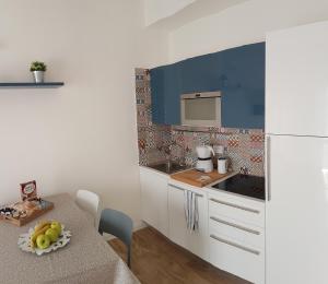 a kitchen with a table and a white refrigerator at Suite Home Sophie in Verona