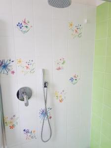 bagno con doccia e fiori sul muro di Suite Home Sophie a Verona