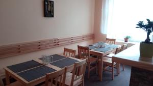 a dining room with wooden tables and chairs and a window at Apartmá Anglická in Františkovy Lázně