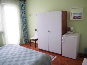 um quarto com um grande armário branco ao lado de uma cama em Muzic Budget Double Room em Mali Lošinj