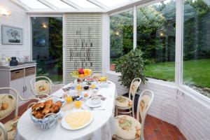een witte tafel met eten op een patio bij Baart's Bed and Breakfast in Wijnandsrade