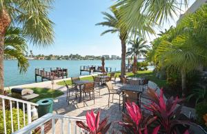 a patio with tables and chairs next to the water at Westwinds Waterfront Resort in St Pete Beach