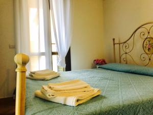 un letto con due asciugamani sopra con una finestra di I mari di Gallura Apartment a San Teodoro