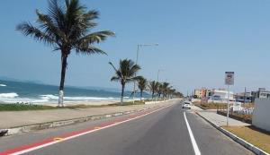 an empty road with palm trees on the beach at Oceano Hotel de Barra Velha in Barra Velha