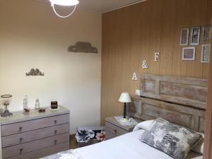 1 dormitorio con cama y cabecero de madera en Casa Rural Fuentesil, en Robles de Laciana