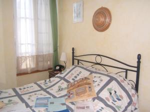 a bedroom with a bed with a quilt on it at Relais du Cap romain in Saint-Aubin-sur-Mer