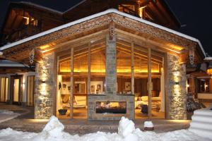 a log home with a fireplace in the snow at Chaletresort Lech in Holzgau