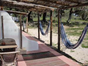 un par de hamacas bajo una pérgola en Ponte Pedra - Melides Country House Adults Only, en Melides