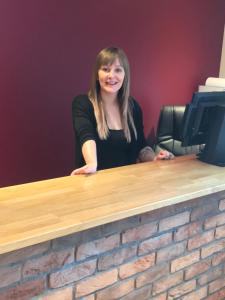 a woman is sitting at a desk with at 19th Hole Hotel, Carnoustie in Carnoustie