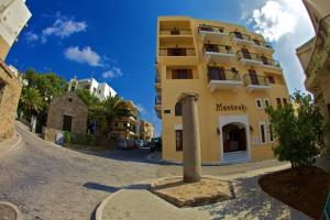 a large building with a clock on the side of it at Mantraki Hotel Apartments in Agios Nikolaos