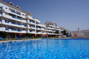 una grande piscina di fronte a un edificio di Duquesa suite and golf with a spectacular sea view a Manilva