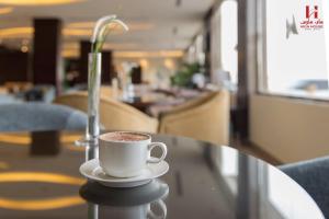 Eine Tasse Kaffee steht auf einem Glastisch in der Unterkunft High House in Sharorah