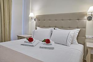 a bed with two red roses on top of it at Element Hotel in Elafonisos