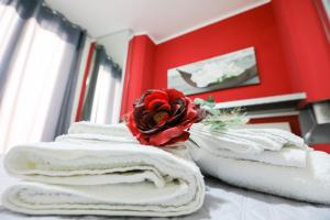 una pila di asciugamani con una rosa sopra di Scabi Apartments a Trapani