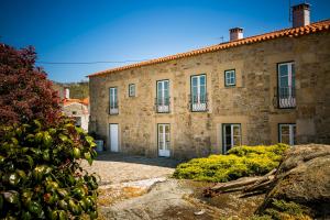 an old stone building with a courtyard in front of it at Casa da Fidalga in Outeiro de Gatos