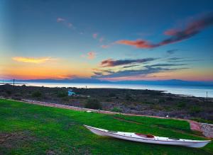 a boat sitting on a grassy field with the sunset at Element Hotel in Elafonisos