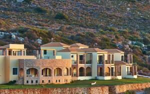 a large house with a hill in the background at Element Hotel in Elafonisos