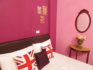 a bedroom with a bed with purple walls and a mirror at Taitung Love Hostel in Taitung City