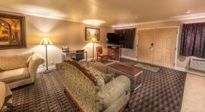a hotel room with a couch and a table and a television at Edge Water Inn in Reedley