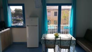 a kitchen with a table with chairs and a window at Casa Vacanze Daniela in Santa Teresa Gallura +3 photos