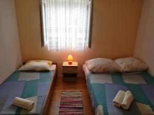 two beds in a small room with a window at Apartments Ema Vir in Vir