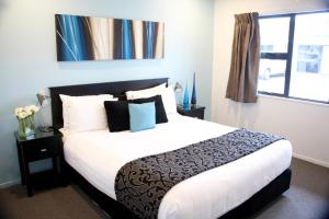a bedroom with a large bed and a window at Camelot On Ulster in Hamilton