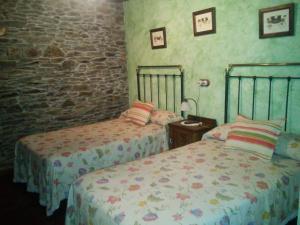 a bedroom with two beds and a brick wall at Casa Colason in El Otero