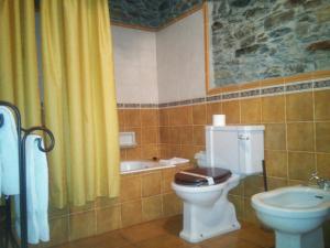 a bathroom with a toilet and a sink and a tub at Casa Colason in El Otero