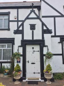 a white and black house with a white door at The Old Coach House in Blackpool