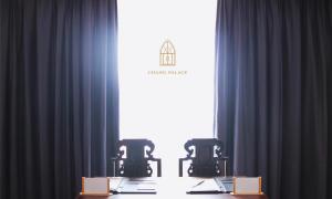 a table with two chairs in front of a window at Chang Palace Vientiane in Vientiane